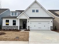Two-story farmhouse-style home with stone accents and a white exterior at 107 N Dunlavin Way # 8, Mooresville, NC 28115