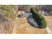 Aerial view of a house with a pool and driveway at 1709 Forest Ridge Dr, Stanley, NC 28164
