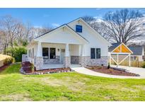 Charming single-Gathering home showcasing a white exterior with stone accents and well-manicured landscaping at 502 Rhyne Cir, Gastonia, NC 28054