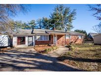 Brick ranch home with a landscaped yard and driveway at 820 Kerley Ct, Statesville, NC 28677