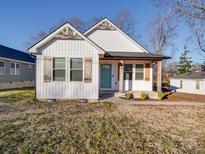 Charming white house with teal door, wooden accents, and landscaped yard at 114 W Lee Ave, Bessemer City, NC 28016