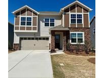 Charming two-story home featuring a stone and siding facade, a two-car garage, and a well-maintained front yard at 1467 Honey Trl, Monroe, NC 28112