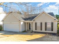 Beige house with two-car garage and landscaped yard at 1828 Sugar Hollow Dr, Charlotte, NC 28214