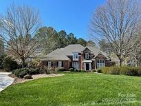 Brick house with a large front lawn and mature trees at 272 Porters Glen Ln, New London, NC 28127