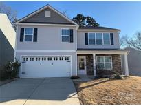 Two-story house with gray siding, stone accents, and a two-car garage at 529 Elmwood Pond Ct, Charlotte, NC 28214