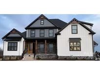New construction home featuring a mix of modern white siding and gray-toned finishes and a welcoming stone-accented porch at 6507 Rehobeth Rd # 4, Waxhaw, NC 28173