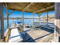 Covered boat dock with seating and water access at 130 Sandy Shore Dr, Mooresville, NC 28117