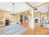 Bright open living room featuring hardwood floors, fireplace, and elegant chandelier lighting at 144 Spring Forest Dr, Shelby, NC 28152