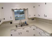 White kitchen with double sink and white cabinets at 2044 Helen Dr, Gastonia, NC 28054