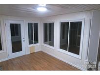 Bright sunroom features wood floors, multiple windows, and a glass door at 2044 Helen Dr, Gastonia, NC 28054