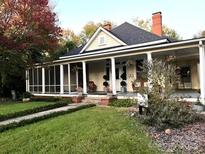 Charming yellow house with wrap-around porch and landscaped yard at 217 Brent St, Wadesboro, NC 28170
