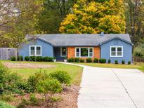 Newly renovated ranch home with a modern facade, landscaped lawn, and long driveway at 4715 Northaven Dr, Charlotte, NC 28206