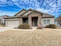 House exterior featuring stone accents and a two-car garage at 1255 Tranquil Falls Ln, Matthews, NC 28104