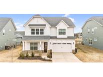 Two-story house with white siding, stone accents, and a two-car garage at 1399 Cedardale Ln, Denver, NC 28037