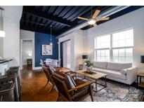 Open-concept living space with a stylish sofa, chairs, and a view into the dining and kitchen at 2338 Yadkin Ave # 203, Charlotte, NC 28205