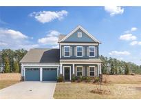 Charming two-story home with blue siding, a two-car garage, and manicured landscaping at 24078 Sailfish Dr # 1152, Lancaster, SC 29720