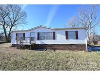 White single-wide mobile home with brown shutters and a wooden deck at 3463 Rock Creek Dr, Newton, NC 28658