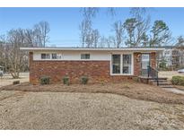 Brick ranch house with a well-manicured lawn at 3512 Carlyle Dr, Charlotte, NC 28208