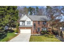 Charming two-story home featuring brick and siding exterior, mature trees, and well-manicured lawn at 100 Melrose Ct, Fort Mill, SC 29715