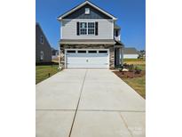Two-story house with gray siding, stone accents, and a two-car garage at 103 Adams Tree Way, Troutman, NC 28166