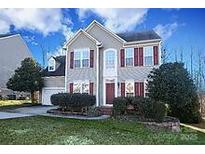 Charming two-story home boasts a manicured lawn, symmetrical design, and classic red shutters at 4030 Garden Oak Dr, Indian Trail, NC 28079