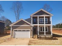 Two-story home features a welcoming front porch, attached garage, and modern architectural details at 8078 Blackwood Rd, Denver, NC 28037