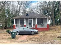 Charming red brick cottage with screened porch and mature trees at 1 Catawba Ave, Great Falls, SC 29055