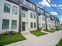 Modern townhome with crisp white exterior and landscaped front yards on a sunny day at 2538 Park Rose Ln # 10, Charlotte, NC 28204