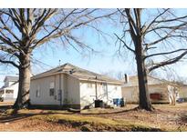 Rear view of a single story house with mature trees and a small yard at 303 Vance Ave, Salisbury, NC 28144