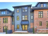 Rear view of a modern home with brick and blue siding, showcasing a patio and landscaping at 3113 Colyer Pl, Charlotte, NC 28205