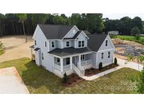 Stunning two-story home featuring a welcoming front porch, gray siding, a well-manicured lawn, and beautiful landscaping at 4251 Candlewood Dr, Sherrills Ford, NC 28673