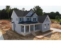 New two-story home boasts a covered front porch with white columns and light blue siding with a dark roof at 4251 Candlewood Dr, Sherrills Ford, NC 28673