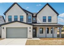 Beautiful two-story home featuring a brick facade, attached garage, and covered front porch with modern dark frame windows at 604 Hyder Trl, Tega Cay, SC 29708