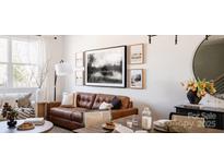 Spacious living room featuring a brown leather sofa and large window at 8018 Elevate Ct, Charlotte, NC 28205