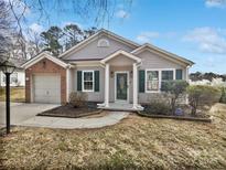 Brick and siding ranch home with attached garage and landscaped yard at 8035 Bristle Ln, Charlotte, NC 28214