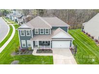 Two-story house with gray siding, two-car garage, and landscaped yard at 8903 Ansley Park Pl, Huntersville, NC 28078