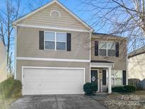 Two-story house with beige siding, white garage door, and landscaping at 11627 Tribal Dr, Charlotte, NC 28214