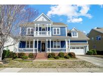 Charming two-story blue home with a welcoming front porch and a well-maintained lawn at 2607 White Pines Ct, Monroe, NC 28112