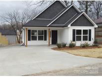 Charming white house with dark gray roof and wood post accents at 303 Gurley St, Kannapolis, NC 28081