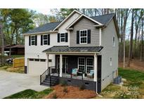 Two-story home featuring a covered front porch, attached garage, and neutral color scheme at 5528 Brickstone Dr, Charlotte, NC 28227
