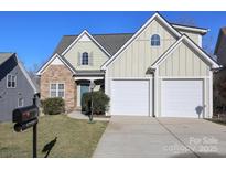 Charming home showcasing a blend of stone and siding, complemented by a well-manicured lawn and two-car garage at 5727 Chalyce Ln, Charlotte, NC 28270