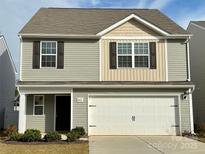 Two-story house with gray siding, beige accents, and a two-car garage at 8112 Derby Woods Ln, Charlotte, NC 28214