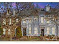 Evening view of charming townhouses with brick and white siding at 9638 Longstone Ln, Charlotte, NC 28277