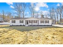 Charming single-story home featuring white brick, black shutters, and a freshly landscaped yard on a sunny day at 1006 Woodside Dr, Kings Mountain, NC 28086