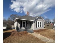 Charming gray house with a porch and well-maintained landscaping at 107 Meadow Ne Ave # 7, Concord, NC 28025