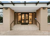 Elegant entryway featuring glass doors, stone accents, and accessible ramp with handrails at 130 Cherokee Rd # 104, Charlotte, NC 28207