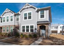 Charming two-story townhome featuring stone accents and a well-maintained lawn on a sunny day at 1342 Galloway Rd # 132, Charlotte, NC 28262