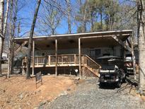 Charming home with a covered porch, a golf cart parked outside, and a well-maintained landscape at 140 Landlubber Trl # H73, Mount Gilead, NC 27306