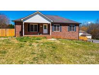 Charming brick home featuring a cozy front porch with classic shutters and a well-manicured lawn at 300 Pine Meadows Cir, Hickory, NC 28601