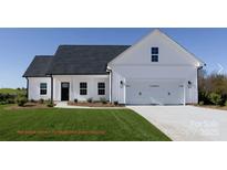 White farmhouse exterior with a two-car garage and landscaped lawn at 3073 Meadowcrest Dr # 26, Clover, SC 29710